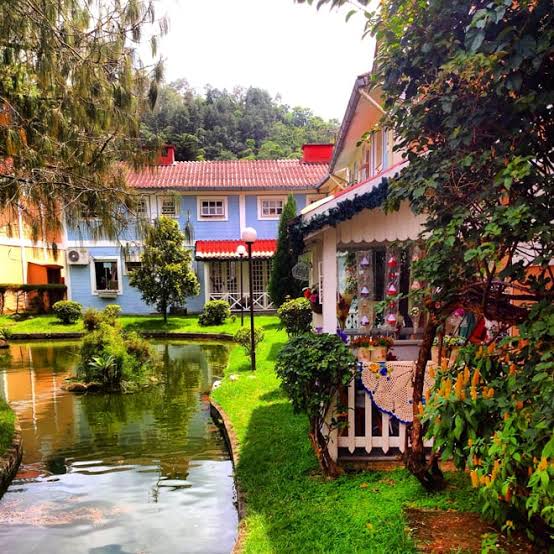 Vila charmosa em Penedo com lago e montanhas ao fundo